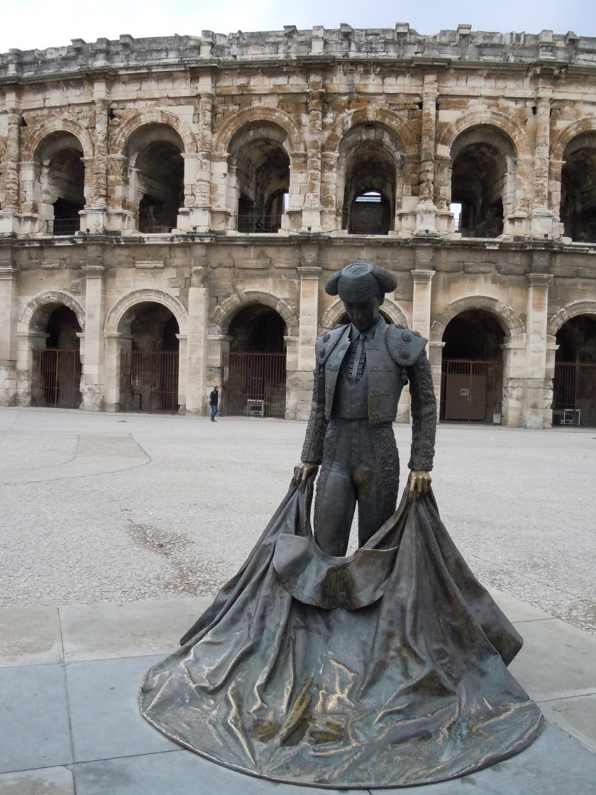A matador statue in front of the ancient Arena of Nîmes.